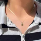 Sterling silver necklace with a teardrop pendant holding a green peridot stone.