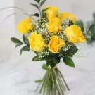 Bouquet of yellow roses with baby's breath and greenery.
