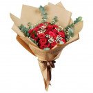A bouquet of red roses with baby's breath and eucalyptus, wrapped in brown paper with "Gorgeous You" text.