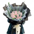 Bouquet of pink roses and eucalyptus, wrapped in black and grey paper, tied with a cream ribbon.