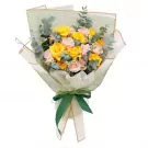 Bouquet of yellow and cream roses with eucalyptus leaves, tied with a green ribbon.