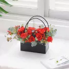 Red roses in a black square basket with handles.