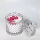 Glass jar candle with pink rose wax melts on top, lid ajar with tag.