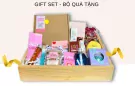 Gift set with bath bombs, body scrub, and assorted beauty products in a wooden crate.