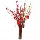 A vase of red and yellow pussy willow branches with red decorative tags and tassels.