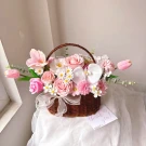 A pink flower basket with roses, orchids, tulips, and daisies.