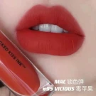 MAC 95 Vicious red liquid lipstick on lips, with product packaging.