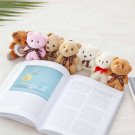 Group of small teddy bears with ribbons on a book.