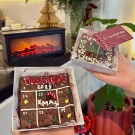 Christmas brownie calendar box with decorated brownies and a fireplace decoration.