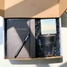 Gift box with "Americano" notebook, black pen, reusable cup, straw, and note card.