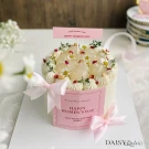 Cream cake decorated with lychee, daisy flowers, and pink ribbon.