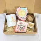 Women's Day gift box with mug, dried flowers, candle, and wooden coaster.