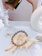 Open white and gold jewelry box with a tiny crown charm.
