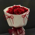 Red soap roses in a white bouquet with red ribbon ties.