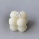 White bubble candle with a white wick on a grey background.