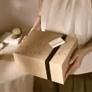 Kraft paper gift box with "sweet bee" calligraphy, tied with black ribbon.