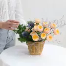 Wicker basket with peach roses, thistle, and greenery.