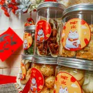Jars of Tết treats featuring lucky cats and Vietnamese New Year motifs.