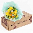 Yellow roses with light blue wrapping on a cardboard box.