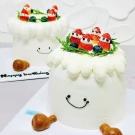 Cute Christmas cake with strawberry snowmen, blueberries, and a smiling face design.