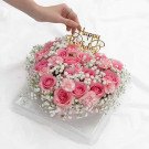 Pink rose and carnation floral cake with baby's breath and "Happy Birthday" topper.