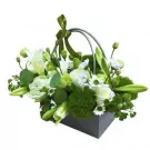 A white and green floral arrangement in a grey basket with a green ribbon bow.