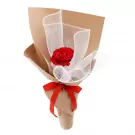 A single red rose in a brown paper bouquet with white mesh and a red ribbon.