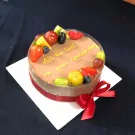 Chocolate mousse cake with fresh fruit and "All the best on your special day" written on top.