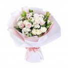 Pink and white roses with carnations and greenery in a pink and white paper wrap, tied with a pink ribbon.