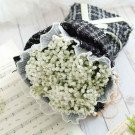 White baby's breath bouquet wrapped in black and white tweed with lace trim.