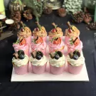 Tropical Fiesta cupcakes: chocolate, strawberry, and vanilla flavors with fruit and chocolate decorations.