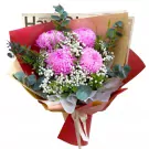 Pink peonies and baby's breath bouquet in red and gold paper wrapping.