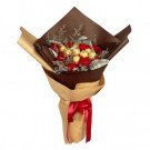 Red carnations and Ferrero Rocher chocolates in a bouquet wrapped in brown and tan paper, tied with a red ribbon.