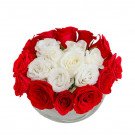 Red and white roses arranged in a glass bowl.