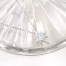 Silver star necklace with an oval moonstone pendant.
