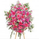 A large, lush floral arrangement in various shades of pink, featuring gerbera daisies, carnations, and chrysanthemums.