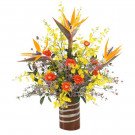 A vibrant floral arrangement with birds of paradise, orchids, and gerbera daisies in a striped vase.