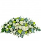 Floral arrangement of white roses and green filler flowers with eucalyptus leaves.