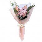 Pink and peach flower bouquet with eucalyptus, wrapped in pale pink paper and tied with a cream ribbon.