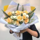 A bouquet of light orange roses, white ping pong mums, and white carnations.