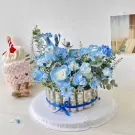 Blue floral money cake with a plush cupcake toy.