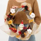 Christmas wreath with dried oranges, pinecones, berries, and a snowman.