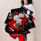 Red and silver roses in a bouquet with black and red wrapping.