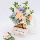 Pastel wedding bouquet with roses, carnations, eustoma, and hydrangeas on a miniature piano.