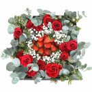 Red roses and strawberries arranged in a square box with eucalyptus and baby's breath.
