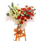 Heart-shaped floral arrangement with red gerberas and yellow carnations on a wooden stand.