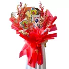 Red and gold Chinese New Year bouquet with Monopoly, lottery tickets, and other festive items.