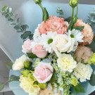 Pastel flower bouquet with pink roses, carnations, eustoma, and hydrangea.
