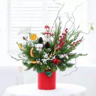 Christmas flower arrangement with a snowman, pinecones, red berries, and dried orange slices in a red vase.