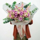 Pink and purple floral bouquet with eucalyptus, tied with a ribbon.